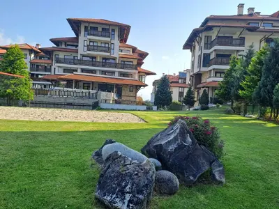 a large apartment building with rocks in the grass at Bansko Royal Towers T&K in Bansko
