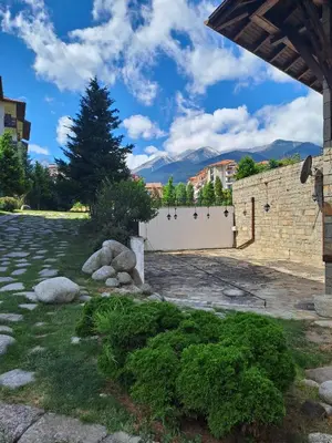 a courtyard with a white fence and a tree at Bansko Royal Towers T&K in Bansko