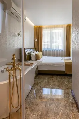 a bedroom with a bed and a shower and a tub at HIDDEN BANK: Cash in Plovdiv