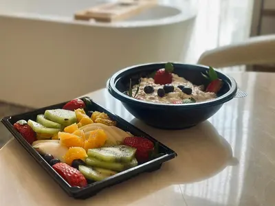 a bowl of oatmeal and a bowl of fruit on a table at HIDDEN BANK: Cash in Plovdiv