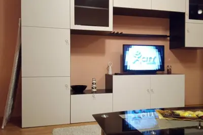 a living room with a tv and white cabinets at Mia's Apartment, Stylish one-bedroom apartment in Sofia
