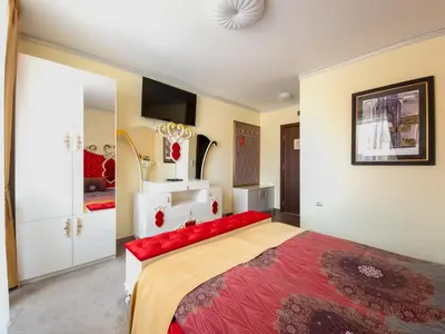 a bedroom with a large bed with a red blanket at Айляк Клуб Велинград - Бутиков Хотел&СПА с Elegant Ultra All Inclusive in Velingrad