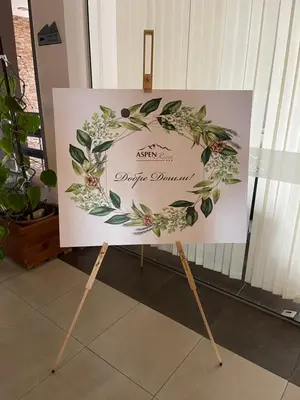 a sign on a stand with a flower wreath at Pirin Dream View Apartments in Razlog