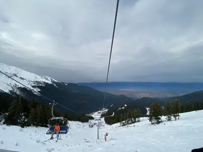 a group of people on a ski lift on a snow covered mountain at CEDAR LODGE NEXT TO LIFT ONE BEDROOM APARTMENT in Bansko