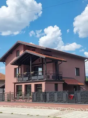 a pink house with a balcony on the side of it at Casa Veneta in Oreshak