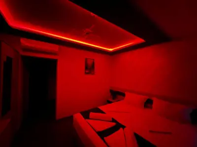 a red room with a bed and a red light at Hotel Central in Karlovo