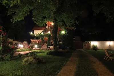 a yard at night with a bench and a house at Orehite Guest House in Samokov