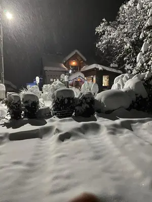 a yard covered in snow in front of a house at Orehite Guest House in Samokov