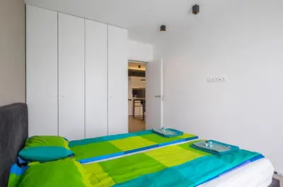 a bed with a colorful blanket on top of it at City Apartments - Mall of Sofia & Metro Station in Sofia
