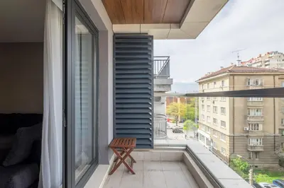 a balcony with a bench and a view of a city at City Apartments - Mall of Sofia & Metro Station in Sofia