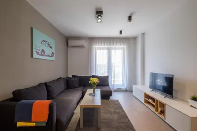 a living room with a couch and a tv at City Apartments - Mall of Sofia & Metro Station in Sofia
