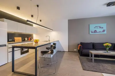 a kitchen and living room with a table and a couch at City Apartments - Mall of Sofia & Metro Station in Sofia