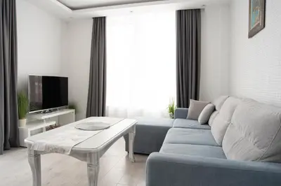 a living room with a blue couch and a table at Sunny & Stylish Brand new 2bdr Apartment + Parking in Sofia