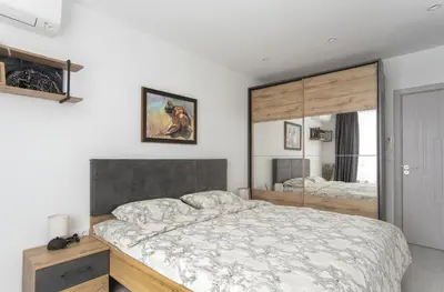 a bedroom with a large bed and a mirror at Sunny & Stylish Brand new 2bdr Apartment + Parking in Sofia