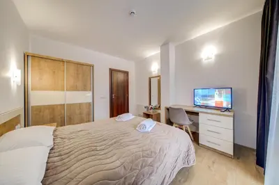 a bedroom with a bed and a desk and a television at Smolyan Lakes Apartment / Апартамент Смолянски езера in Smolyan