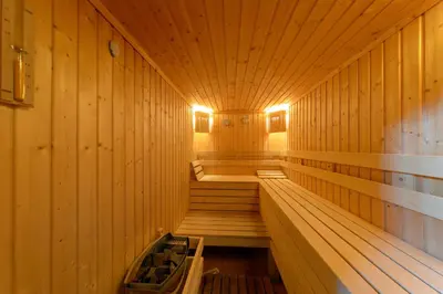 a sauna with wooden walls and wooden stairs in it at Smolyan Lakes Apartment / Апартамент Смолянски езера in Smolyan