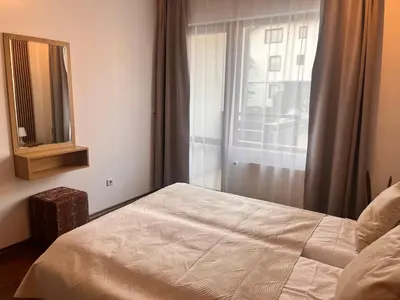 a bedroom with a bed and a mirror and a window at St. Anastasia Apartments in Bansko