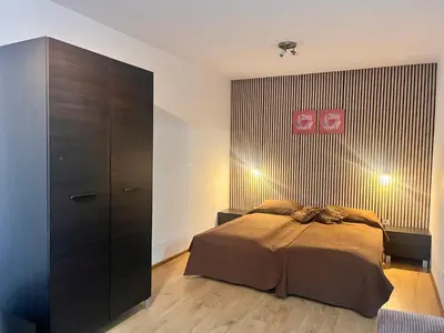 a bedroom with a bed and a large cabinet at St. Anastasia Apartments in Bansko