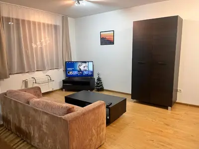 a living room with a couch and a tv at St. Anastasia Apartments in Bansko