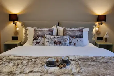 a bed with two cups and a tray on it at PinePino Borovets, aparthotel Borovets Gardens A60 in Borovets