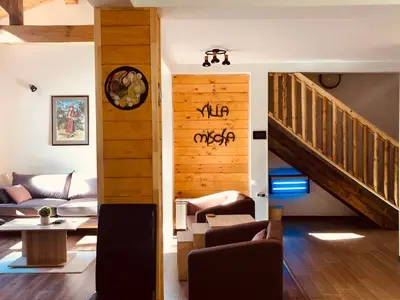 a living room with a staircase and a couch at Villa Mischa in Grashtitsa