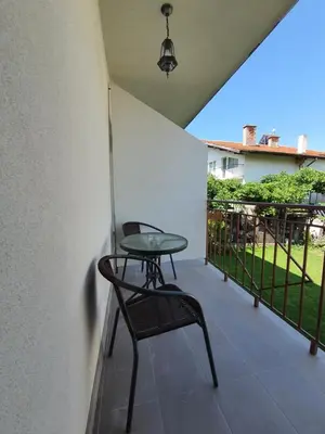 a table and a chair on a balcony at Дамяновата къща in Sapareva Banya