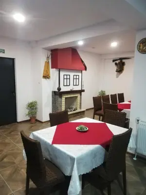 a dining room with a red and white table and a fireplace at Вила ОБЗОР in Progled