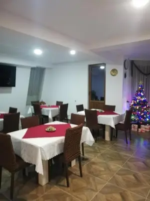 a dining room with tables and a christmas tree at Вила ОБЗОР in Progled