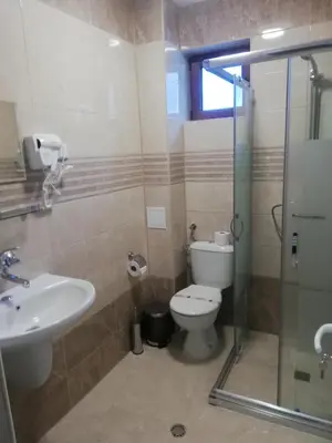 a bathroom with a toilet and a sink and a shower at Вила ОБЗОР in Progled