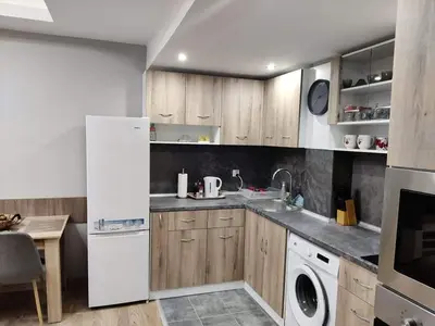a kitchen with wooden cabinets and a white refrigerator at Apartment Anelia 1 in Plovdiv