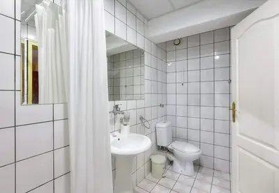 a white bathroom with a toilet and a sink at HOTEL THE WHITE HOUSE Plovdiv in Plovdiv