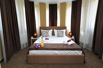 a bedroom with a large bed with flowers on it at HOTEL THE WHITE HOUSE Plovdiv in Plovdiv