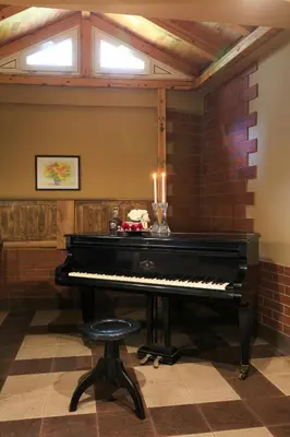 a piano in a room with a brick wall at HOTEL THE WHITE HOUSE Plovdiv in Plovdiv