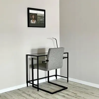 a glass table with a chair and a picture on the wall at ATRIUM Boutique Suites Sofia in Sofia