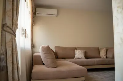a living room with a couch and a window at Хотел България Петрич in Petrich