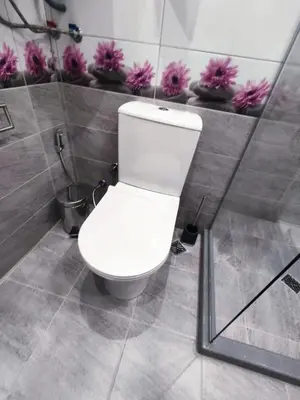 a white toilet in a bathroom with pink flowers at Mountain view apartment in Sofia