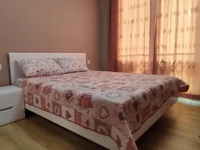 a bedroom with a bed and a window with curtains at Mountain view apartment in Sofia