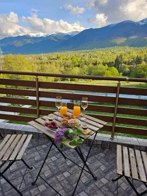 a table with glasses of orange juice and a plate of food at Къща за гости Радост Guest House Radost in Razlog