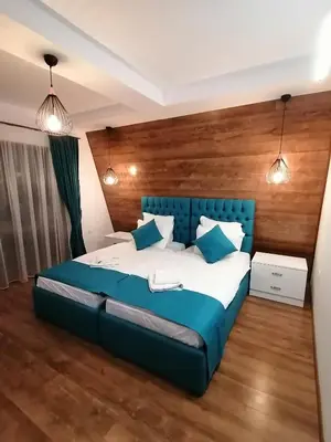 a bedroom with a blue bed and two lights at Къща за гости Радост Guest House Radost in Razlog