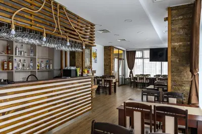 a restaurant with a bar and tables and chairs at Семеен хотел При Вергил in Sapareva Banya