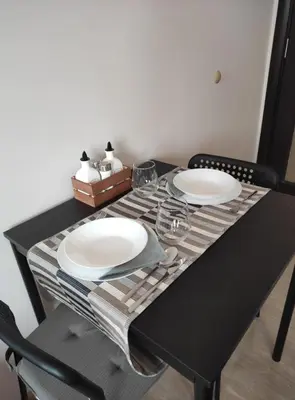 a black table with two plates and glasses on it at Your place in Plovdiv