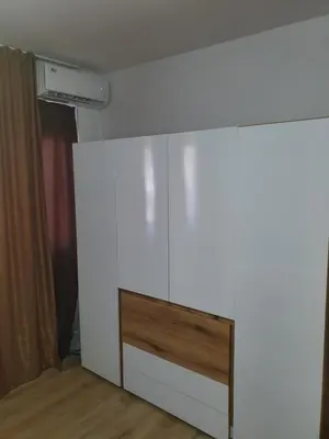 a room with a white wall with a dresser at THE CENTER Apartments Comfort in Sandanski