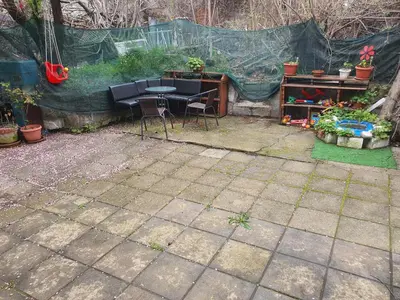 a patio with a table and chairs in a garden at Тих двустаен самостоятелен апартамент с двор,до площада на Сандански in Sandanski