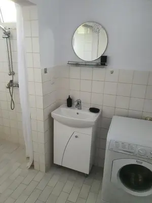 a bathroom with a sink and a washing machine at Тих двустаен самостоятелен апартамент с двор,до площада на Сандански in Sandanski