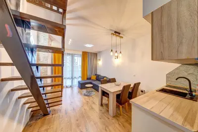 a kitchen and living room with a spiral staircase at Skyday Penthouse Deluxe at Oak Residence in Smolyan