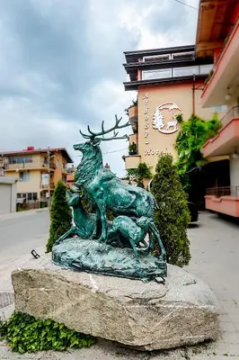 a statue of a deer on a rock in front of a building at Ardo Spa Hotel and Restaurant in Sarnitsa
