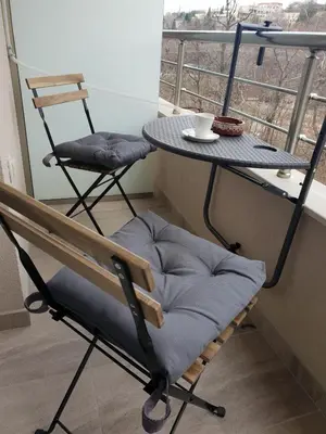 a chair and a table with a cup on a balcony at Riverpark Holiday Apartment, Sandanski in Sandanski