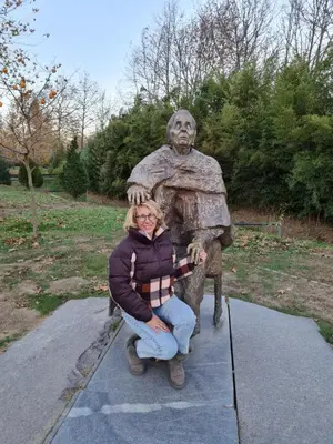 a woman sitting in front of a statue at Riverpark Holiday Apartment, Sandanski in Sandanski