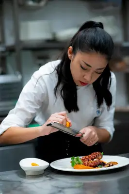 a woman is looking at a plate of food at VIZUALIZA Residence Hotel by HMG in Plovdiv