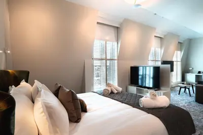 a bedroom with a large bed with a flat screen tv at VIZUALIZA Residence Hotel by HMG in Plovdiv